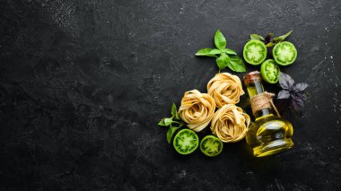 Kuru makarna, domates, yeşillik, yağ ve malzemeler. İtalyan geleneksel mutfağı. Taze sebzeler. Üst Manzara. Metnin için boş yer.