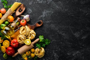 Kuru makarna, domates, yeşillik, yağ ve malzemeler. İtalyan geleneksel mutfağı. Taze sebzeler. Üst Manzara. Metnin için boş yer.