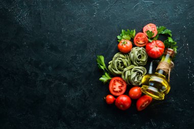 Domatesli çiğ yeşil makarna, beyaz ahşap arka planda yağ ve maydanoz. İtalyan geleneksel mutfağı. Taze sebzeler. Üst Manzara. Metnin için boş yer.