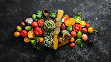 Domatesli çiğ yeşil makarna, beyaz ahşap arka planda yağ ve maydanoz. İtalyan geleneksel mutfağı. Taze sebzeler. Üst Manzara. Metnin için boş yer.