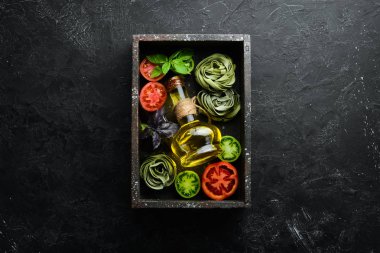 Domatesli çiğ yeşil makarna, beyaz ahşap arka planda yağ ve maydanoz. İtalyan geleneksel mutfağı. Taze sebzeler. Üst Manzara. Metnin için boş yer.