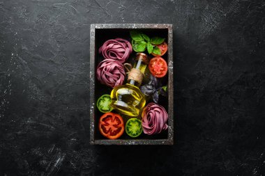 Renkli domates yağı ve maydanozlu kuru makarna. İtalyan geleneksel mutfağı. Taze sebzeler. Üst Manzara. Metnin için boş yer.