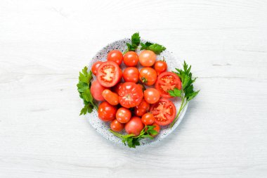 Siyah taşlı arka planda bir tabakta domatesler. Sebzeler. Üst Manzara. Metnin için boş yer.