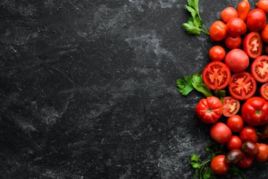 Beyaz ahşap zemin üzerinde taze kırmızı domatesler. Yeşiller. Üst Manzara. Metnin için boş yer.