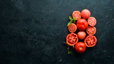 Beyaz ahşap zemin üzerinde taze kırmızı domatesler. Yeşiller. Üst Manzara. Metnin için boş yer.