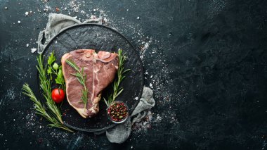 Beyaz ahşap masada çiğ biftek. Üst Manzara. Metnin için boş yer.