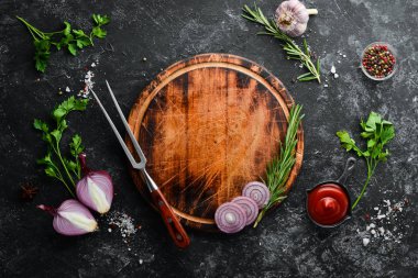 Siyah taş pişirme arka planı. Baharat ve sebze. Üst Manzara. Metnin için boş yer.
