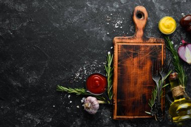 Siyah taş pişirme arka planı. Baharat ve sebze. Üst Manzara. Metnin için boş yer.