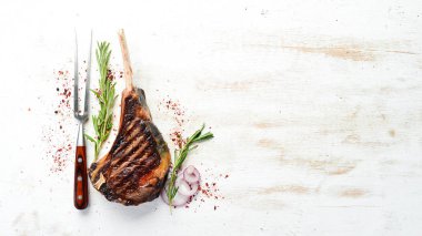 Kemiğin üzerinde biberiye ve baharatla ızgara Tomahawk bifteği. Üst Manzara. Metnin için boş yer.