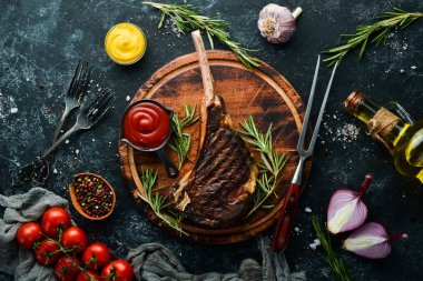 Kemiğin üzerinde biberiye ve baharatla ızgara Tomahawk bifteği. Üst Manzara. Metnin için boş yer.