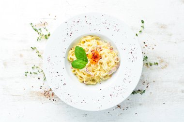 Geleneksel İtalyan makarna yemeği, yumurtalı spagetti carbonara, tabakta parmesan peyniri. Üst Manzara. Boş kopyalama alanı.