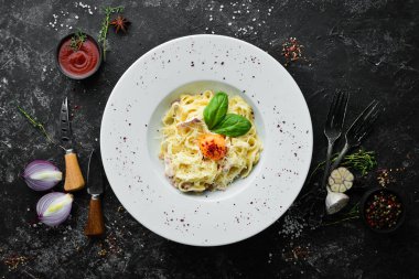 Geleneksel İtalyan makarna yemeği, yumurtalı spagetti carbonara, tabakta parmesan peyniri. Üst Manzara. Boş kopyalama alanı.