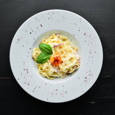 Geleneksel İtalyan makarna yemeği, yumurtalı spagetti carbonara, tabakta parmesan peyniri. Üst Manzara. Boş kopyalama alanı.