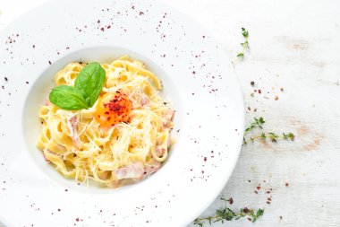 Geleneksel İtalyan makarna yemeği, yumurtalı spagetti carbonara, tabakta parmesan peyniri. Üst Manzara. Boş kopyalama alanı.