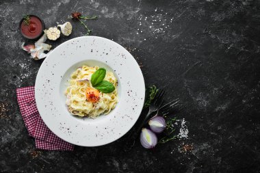 Geleneksel İtalyan makarna yemeği, yumurtalı spagetti carbonara, tabakta parmesan peyniri. Üst Manzara. Boş kopyalama alanı.