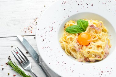 Geleneksel İtalyan makarna yemeği, yumurtalı spagetti carbonara, tabakta parmesan peyniri. Üst Manzara. Boş kopyalama alanı.