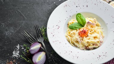Geleneksel İtalyan makarna yemeği, yumurtalı spagetti carbonara, tabakta parmesan peyniri. Üst Manzara. Boş kopyalama alanı.