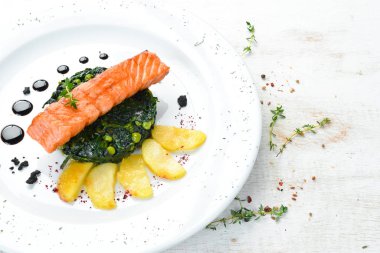 Fırında somon fileto, ıspanaklı ve elmalı bir tabak. Üst Manzara. Boş kopyalama alanı.