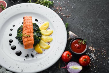 Fırında somon fileto, ıspanaklı ve elmalı bir tabak. Üst Manzara. Boş kopyalama alanı.