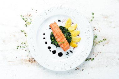 Fırında somon fileto, ıspanaklı ve elmalı bir tabak. Üst Manzara. Boş kopyalama alanı.