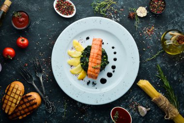 Fırında somon fileto, ıspanaklı ve elmalı bir tabak. Üst Manzara. Boş kopyalama alanı.