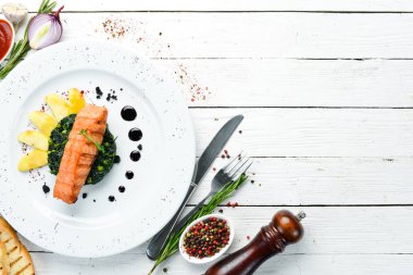 Fırında somon fileto, ıspanaklı ve elmalı bir tabak. Üst Manzara. Boş kopyalama alanı.