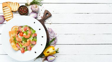 Karides ve kiraz domatesli sebze salatası. Karidesli Sezar salatası. Üst Manzara. Metnin için boş yer.