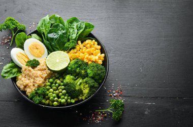 Yeşil sebze kasesi Buda. Kinoa, yeşil bezelye, mısır, ıspanak, brokoli, yumurta. Sağlıklı yiyecekler. Üst Manzara. Metnin için boş yer.