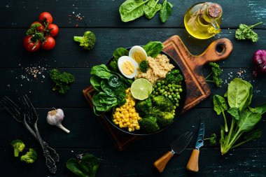 Yeşil sebze kasesi Buda. Kinoa, yeşil bezelye, mısır, ıspanak, brokoli, yumurta. Sağlıklı yiyecekler. Üst Manzara. Metnin için boş yer.