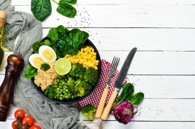 Yeşil sebze kasesi Buda. Kinoa, yeşil bezelye, mısır, ıspanak, brokoli, yumurta. Sağlıklı yiyecekler. Üst Manzara. Metnin için boş yer.