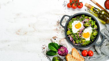 Sebzeli Shakshuka tavada. Sebzeli sahanda yumurta brokoli, bezelye, fasulye, soğan. Üst Manzara. Metnin için boş yer.