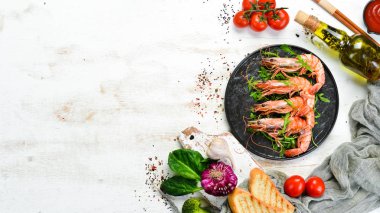 Siyah bir tabakta kaynamış karides ve roka. Deniz ürünleri tabakları. Üst Manzara. Metnin için boş yer.