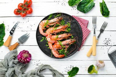 Siyah bir tabakta kaynamış karides ve roka. Deniz ürünleri tabakları. Üst Manzara. Metnin için boş yer.