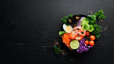 Buda kâsesi dolusu deniz ürünü. Karides, midye, lahana, vişneli domates, ıspanak. Deniz ürünleri tabakları. Üst Manzara. Metnin için boş yer.