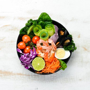 Buda kâsesi dolusu deniz ürünü. Karides, midye, lahana, vişneli domates, ıspanak. Deniz ürünleri tabakları. Üst Manzara. Metnin için boş yer.