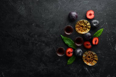 Slivovica - Siyah taş bir masada gözlüklü erik brendisi. Üst Manzara. Metnin için boş yer.