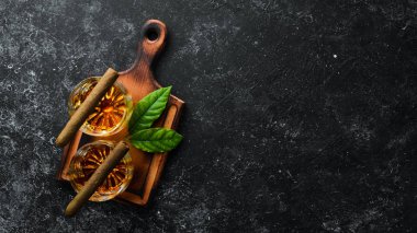 Bardakta viski ve siyah taş bir masada Küba purosu. Üst Manzara. Metnin için boş yer.