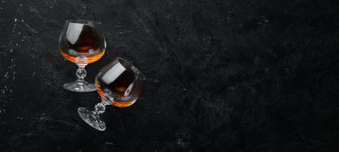 Siyah taş bir masada bardakta konyak. Üst Manzara. Metnin için boş yer.