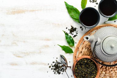 Su ısıtıcılı Çin yeşil çayı. Siyah taştan bir arka planda. Üst Manzara. Metnin için boş yer.