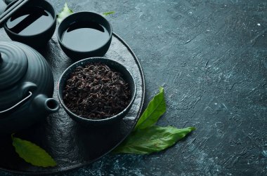 Çaydanlık ile geleneksel siyah çay. Siyah taştan bir arka planda. Üst Manzara. Metnin için boş yer.