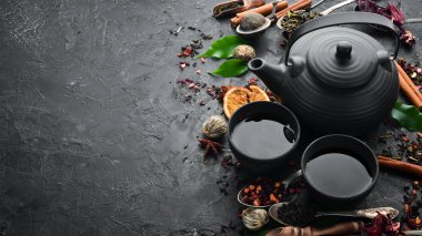 Geleneksel Çin çayını siyah taş zemin üzerine koyun. Çaydanlık ve fincanda çay. Üst Manzara. Metnin için boş yer.