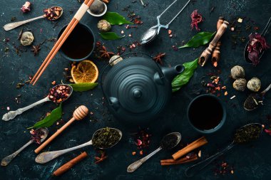 Geleneksel Çin çayını siyah taş zemin üzerine koyun. Çaydanlık ve fincanda çay. Üst Manzara. Metnin için boş yer.