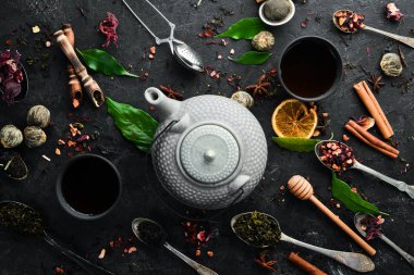 Siyah, yeşil, siyah taştan arka planda meyve ve bitki çayı. Çaydanlık ve fincanda çay. Üst Manzara. Metnin için boş yer.