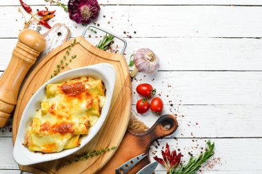 Et, krem sosu ve peynirle pişirilmiş Cannelloni ezmesi. İtalyan mutfağı. Üst Manzara. Boş kopyalama alanı.