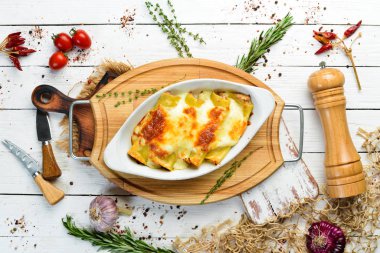 Et, krem sosu ve peynirle pişirilmiş Cannelloni ezmesi. İtalyan mutfağı. Üst Manzara. Boş kopyalama alanı.