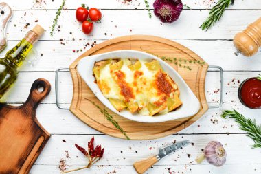 Et, krem sosu ve peynirle pişirilmiş Cannelloni ezmesi. İtalyan mutfağı. Üst Manzara. Boş kopyalama alanı.