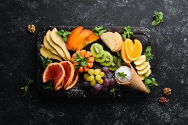 Tahta üzerinde dondurmayla meyve dilimleme. Üst Manzara. Boş kopyalama alanı.