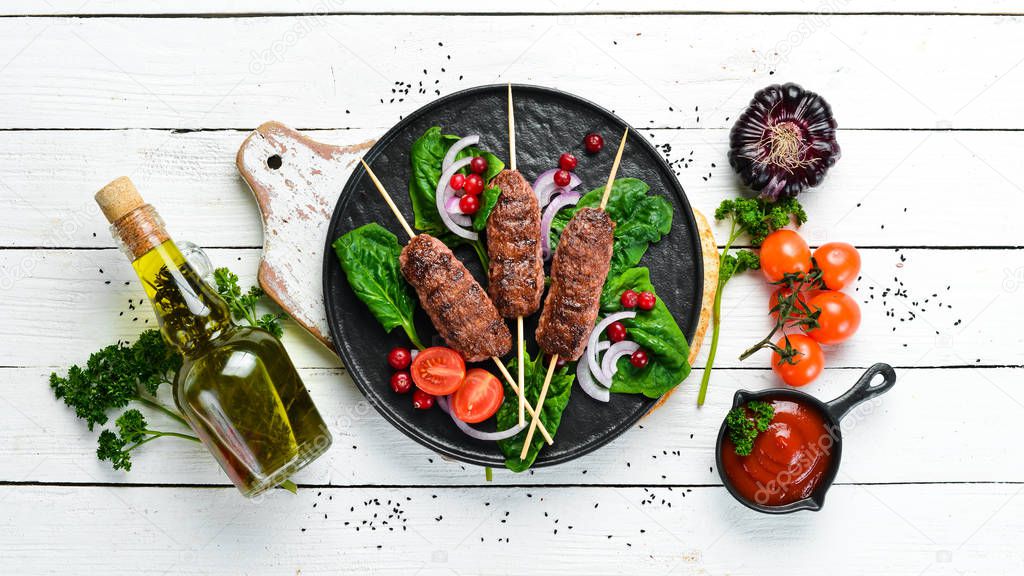 Kebab. Traditional middle eastern, arabic or mediterranean meat kebab with vegetables and herbs. Top view. Free space for your text.