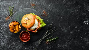 Camembert peynirli hamburger ve et. Patates kızartması ve ketçap. Üst görünüm, metin için boş alan. Kırsal biçim.
