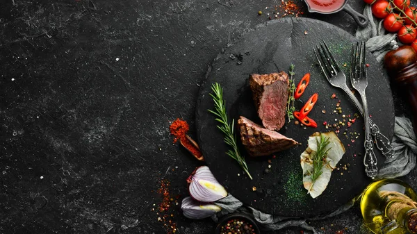 烤牛肉和香料在黑色的石板上 胡椒牛排 顶部视图 为您的文字腾出空间 乡村风格 — 图库照片